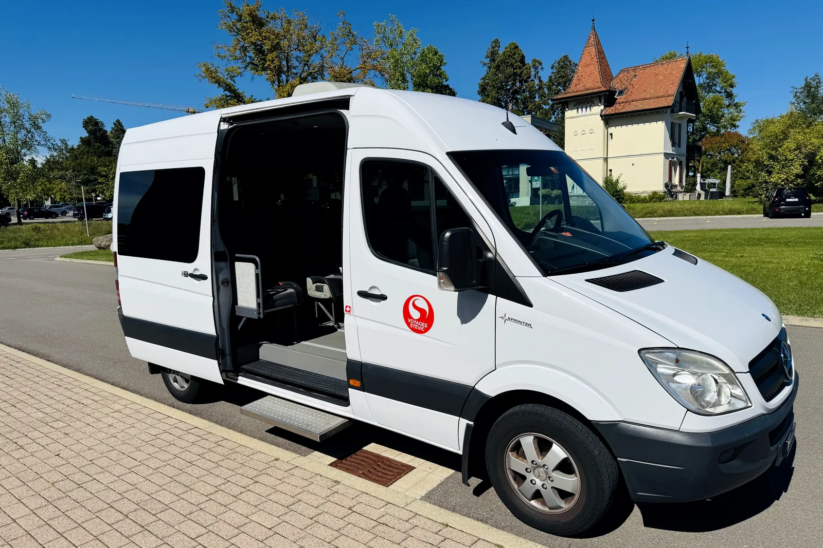 Voyages Stevic Sàrl 13-seat Sprinter minibus with the side door open