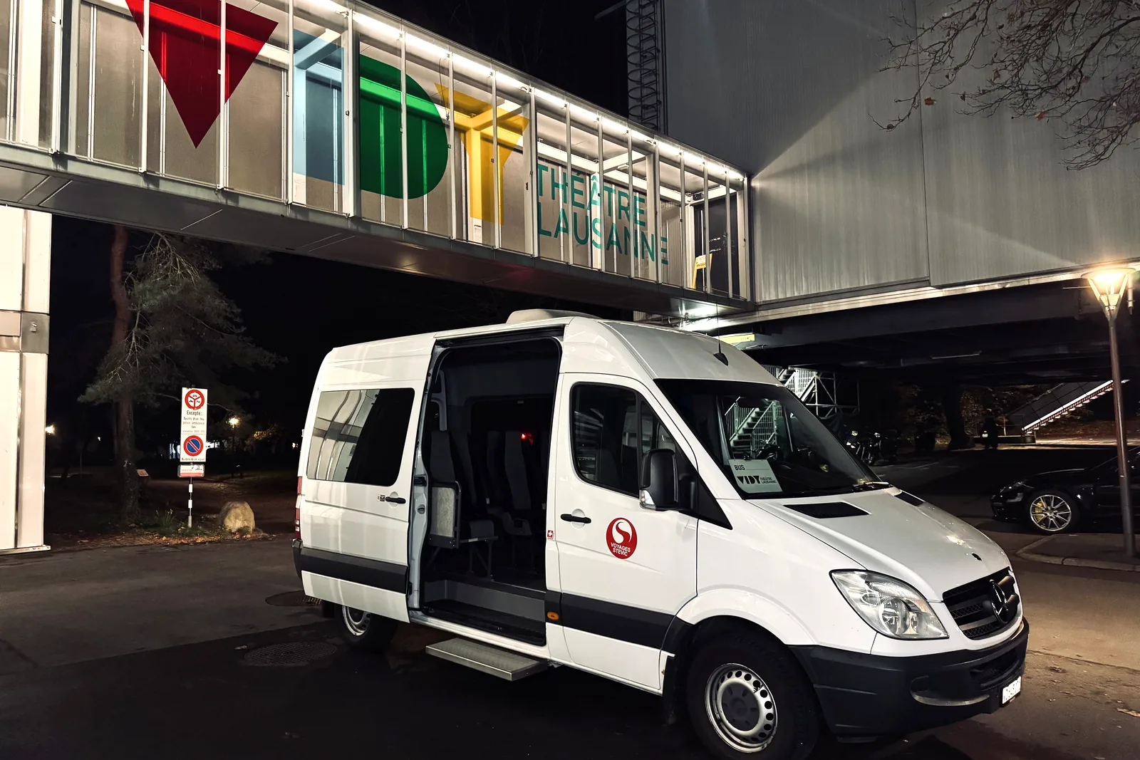 Voyages Stevic Sàrl 13-seat Sprinter minibus in the evening in front of the Théâtre de Vidy
