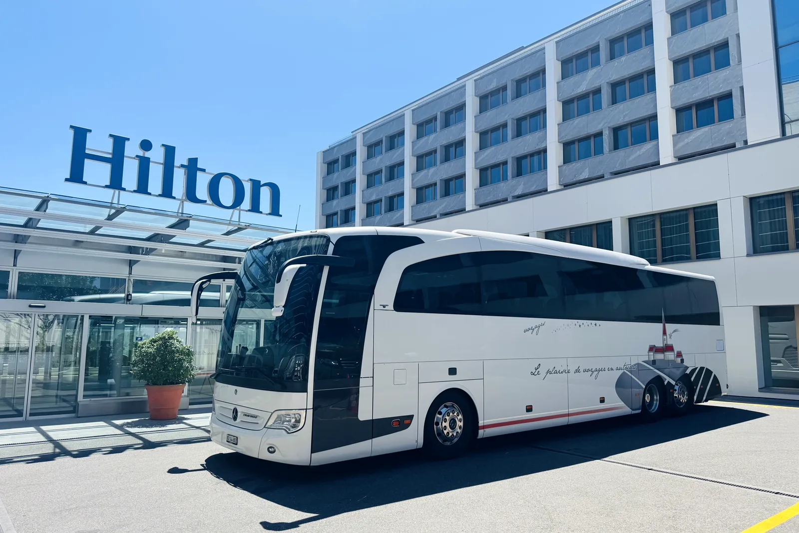 Voyages Stevic Sàrl Mercedes-Benz Travego coach in front of a Hilton hotel