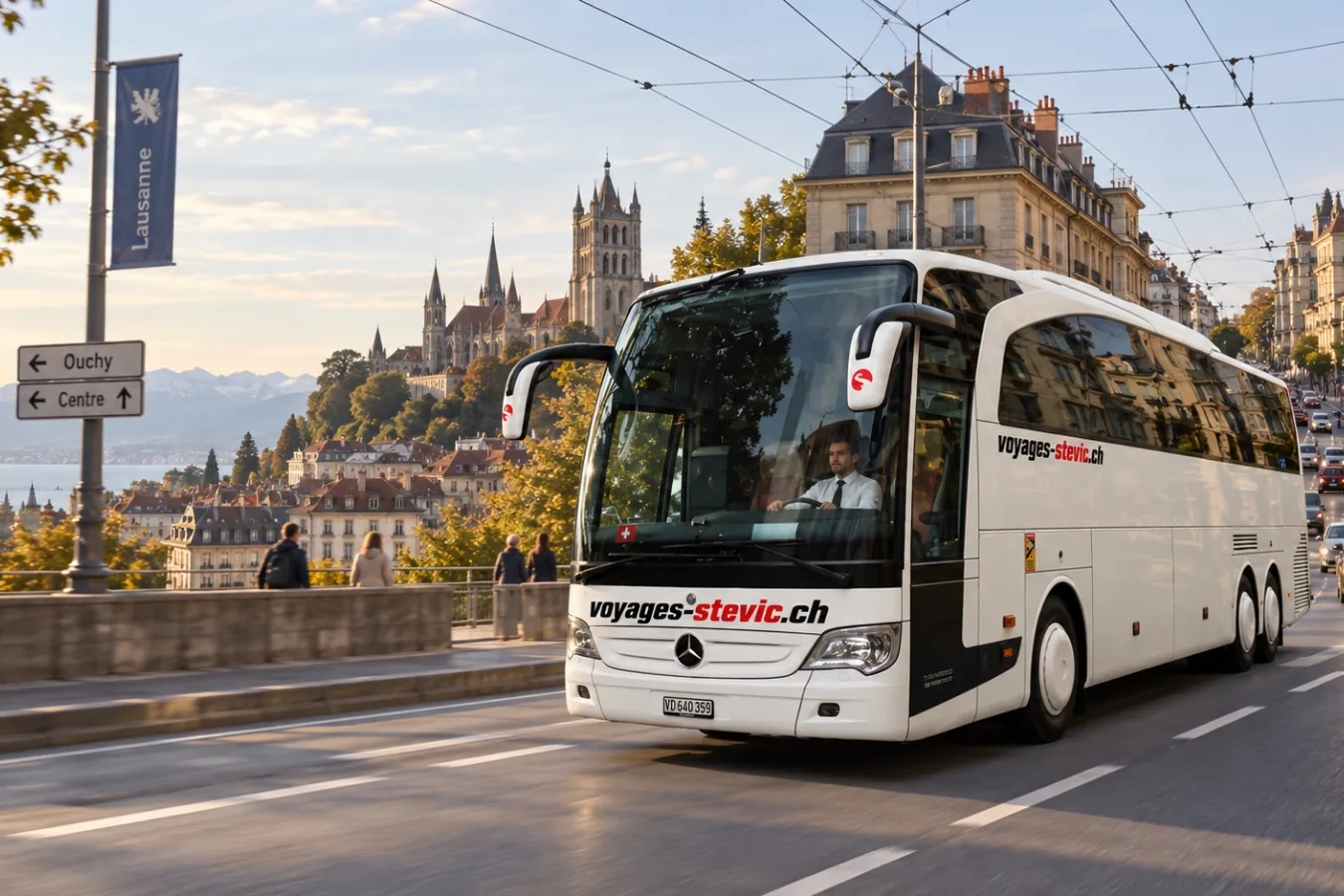 Voyages Stevic Sàrl second Mercedes-Benz Travego coach driving through Lausanne, the cathedral behind